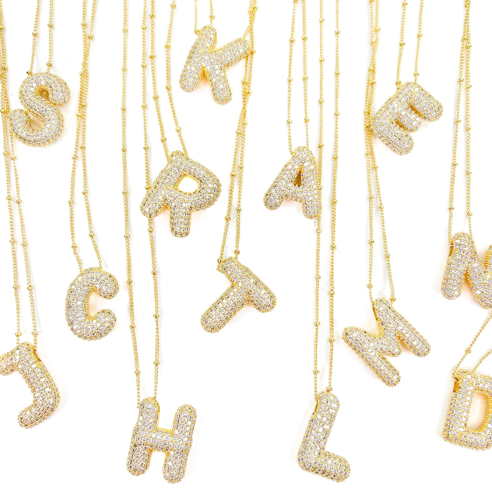 A Bunch of gold necklaces with the Letters pendant - Form + Content