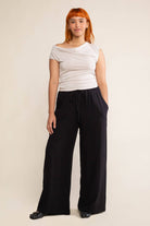 Woman wearing black, wide leg, cove linen pant and white tee