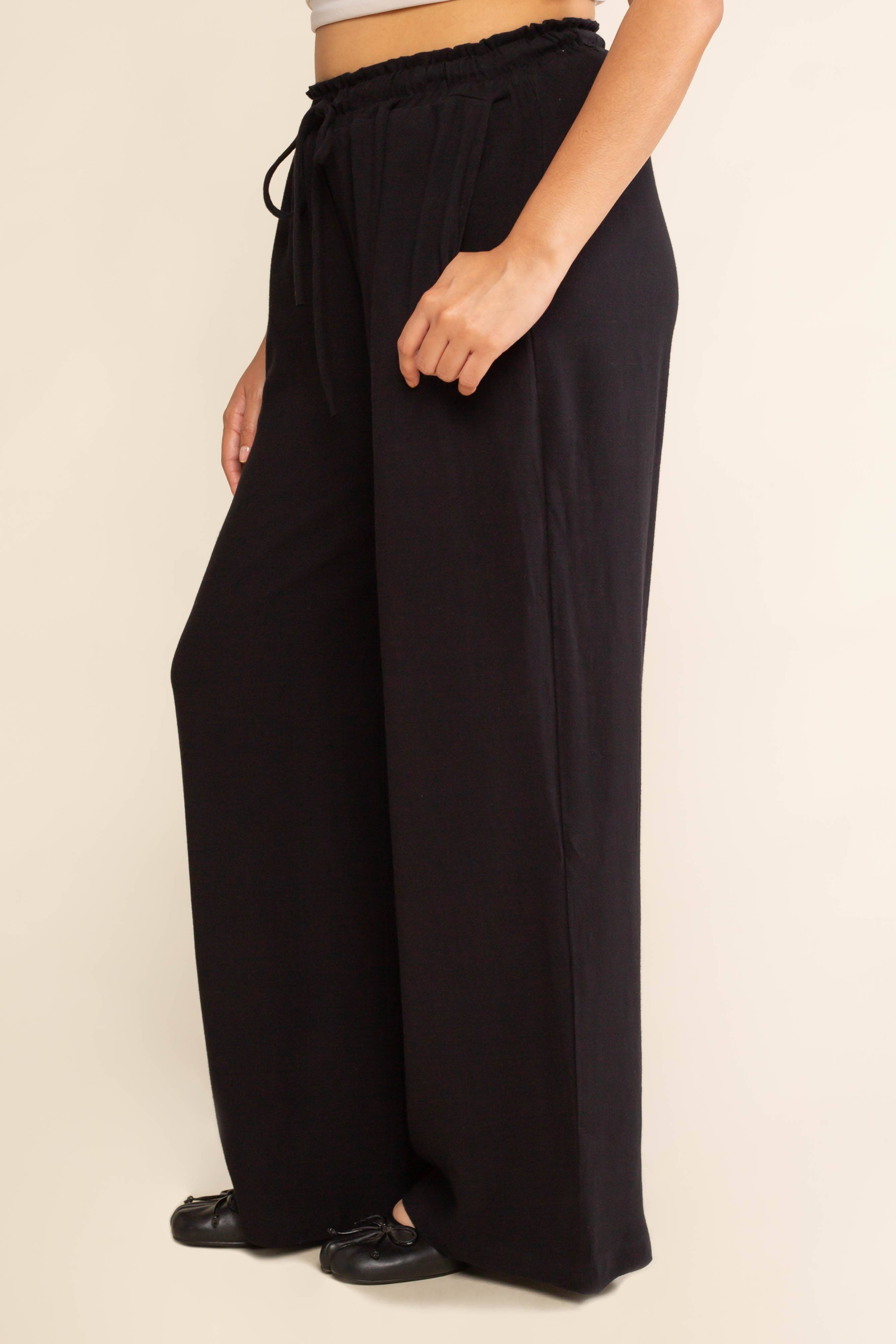 Woman wearing black, wide leg, cove linen pant and white tee