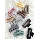 Muted Matte Hair Clip shown in 10 colors laying flat on white fabric 