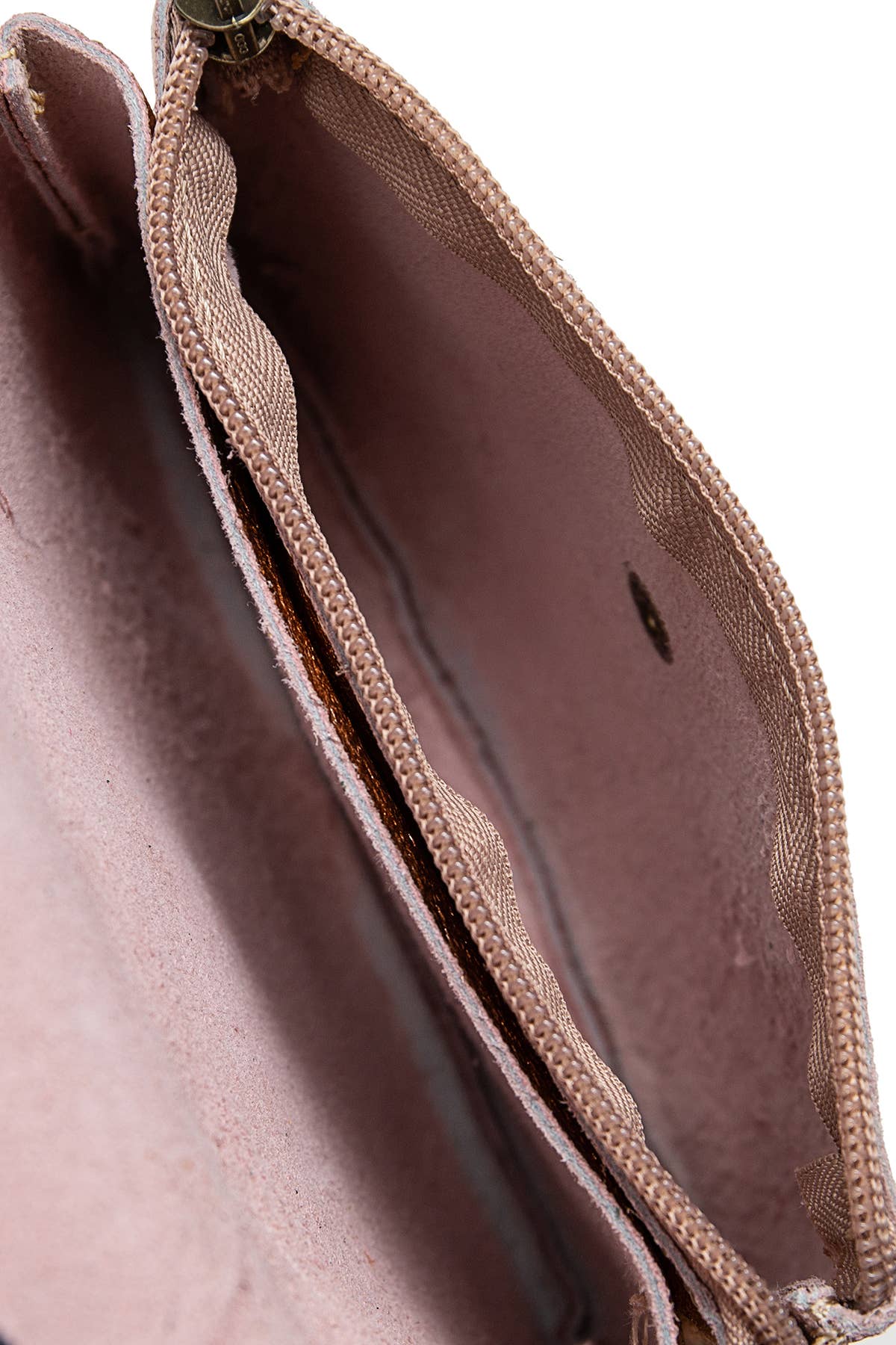 Close-up of the interior of a dusty rose or mauve zippered pouch or wallet, showing the fabric lining and zipper track against a white background.