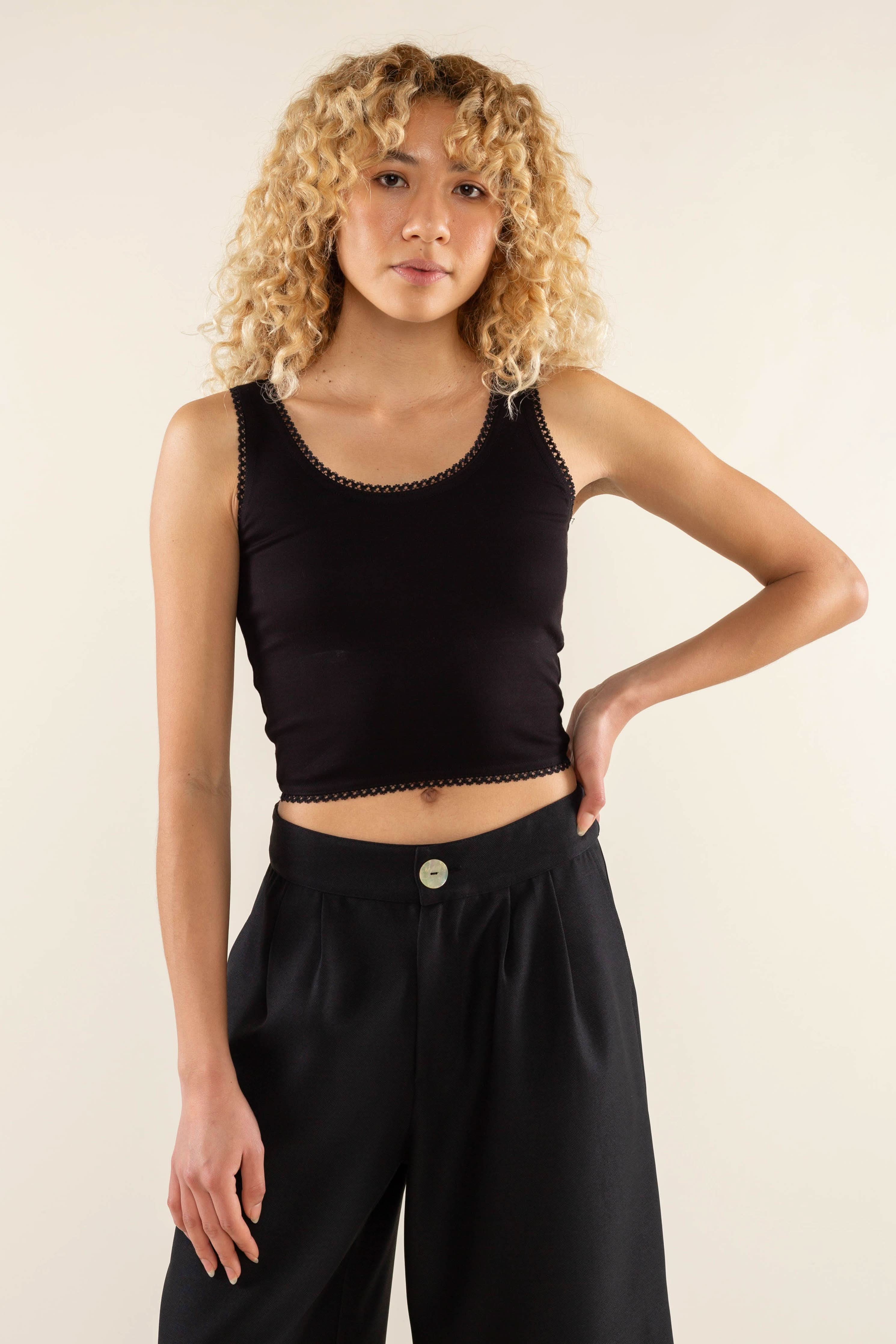 Woman wearing black, scallop trim, crop top with black jorts 