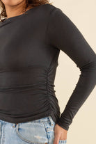 Woman wearing vintage black, shirred waist, long sleeve top 