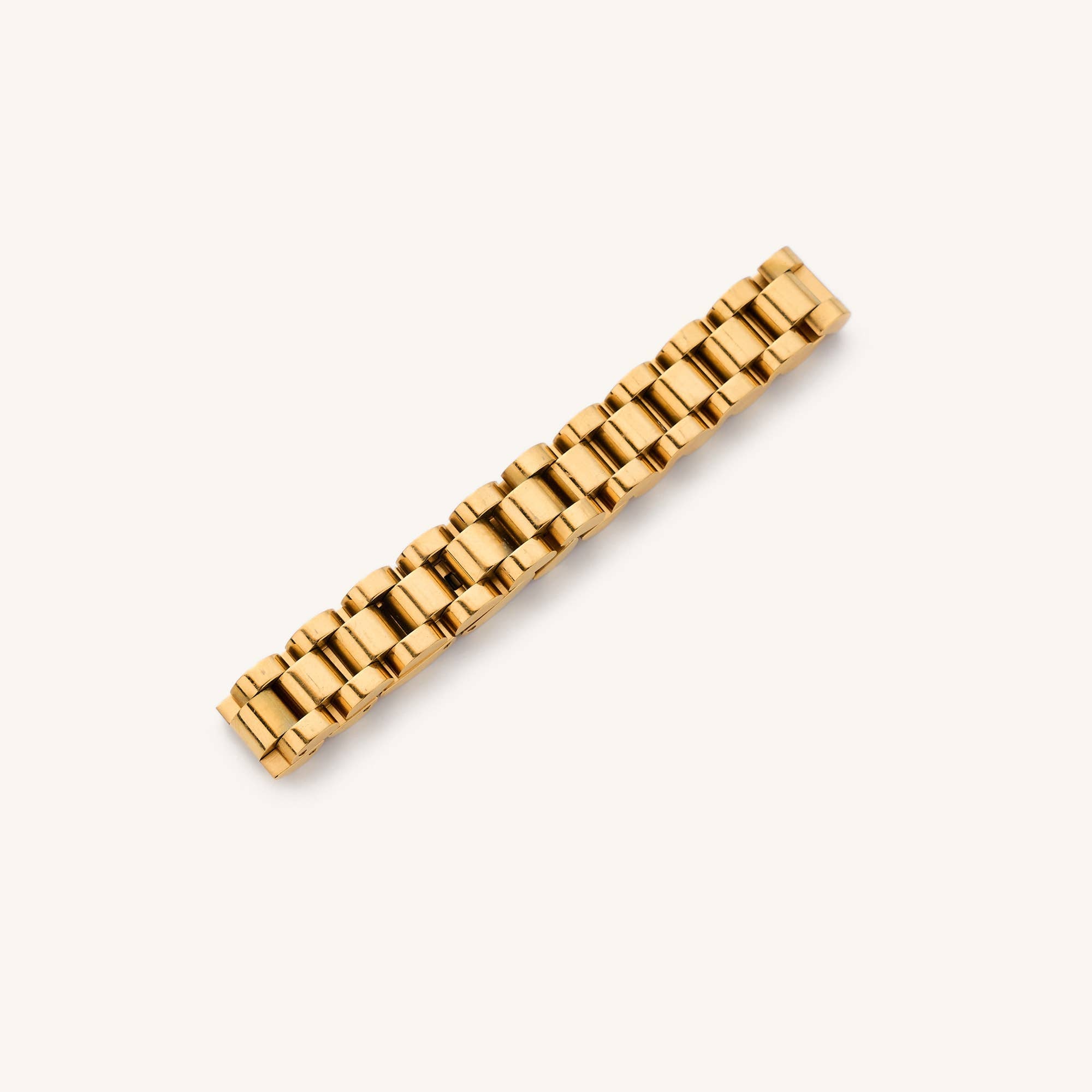 Gold watchband bracelet laying in a white background 