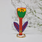 Colorful tulip keychain behind foliage background. 