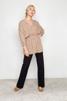 Woman wearing flats and black Micah pants that are skinny on the top with wide bottom