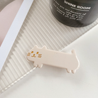 White cat barrette laying flat on white textured surface 