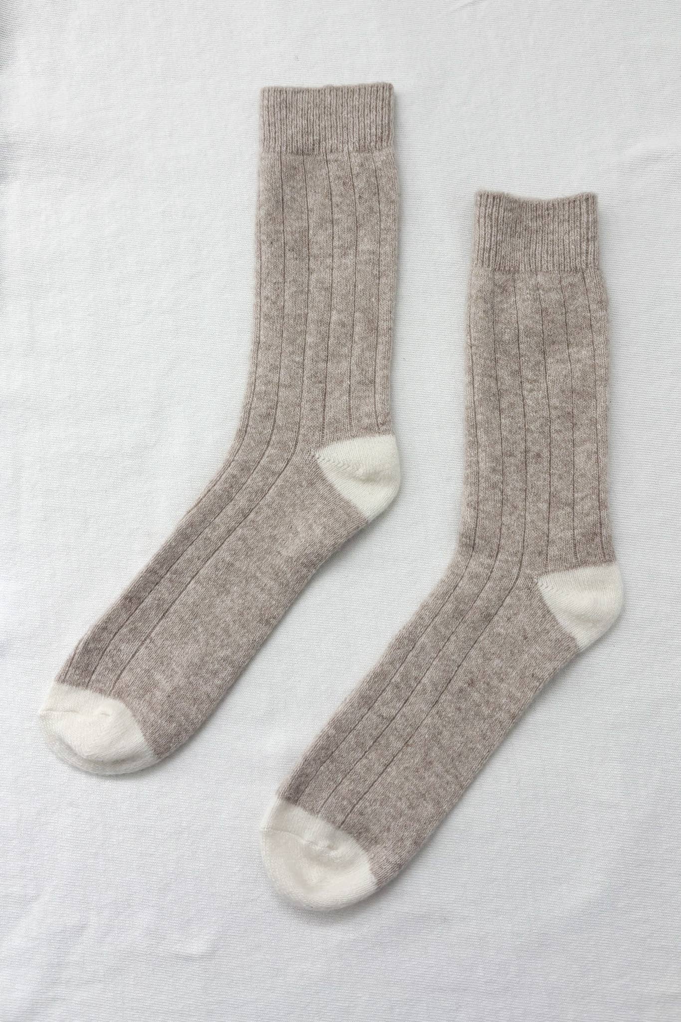 Tan socks that go up to the calf with crème coloring on the heel and toe. 