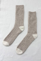 Tan socks that go up to the calf with crème coloring on the heel and toe. 