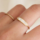Person wearing ring with bar shaped pearl