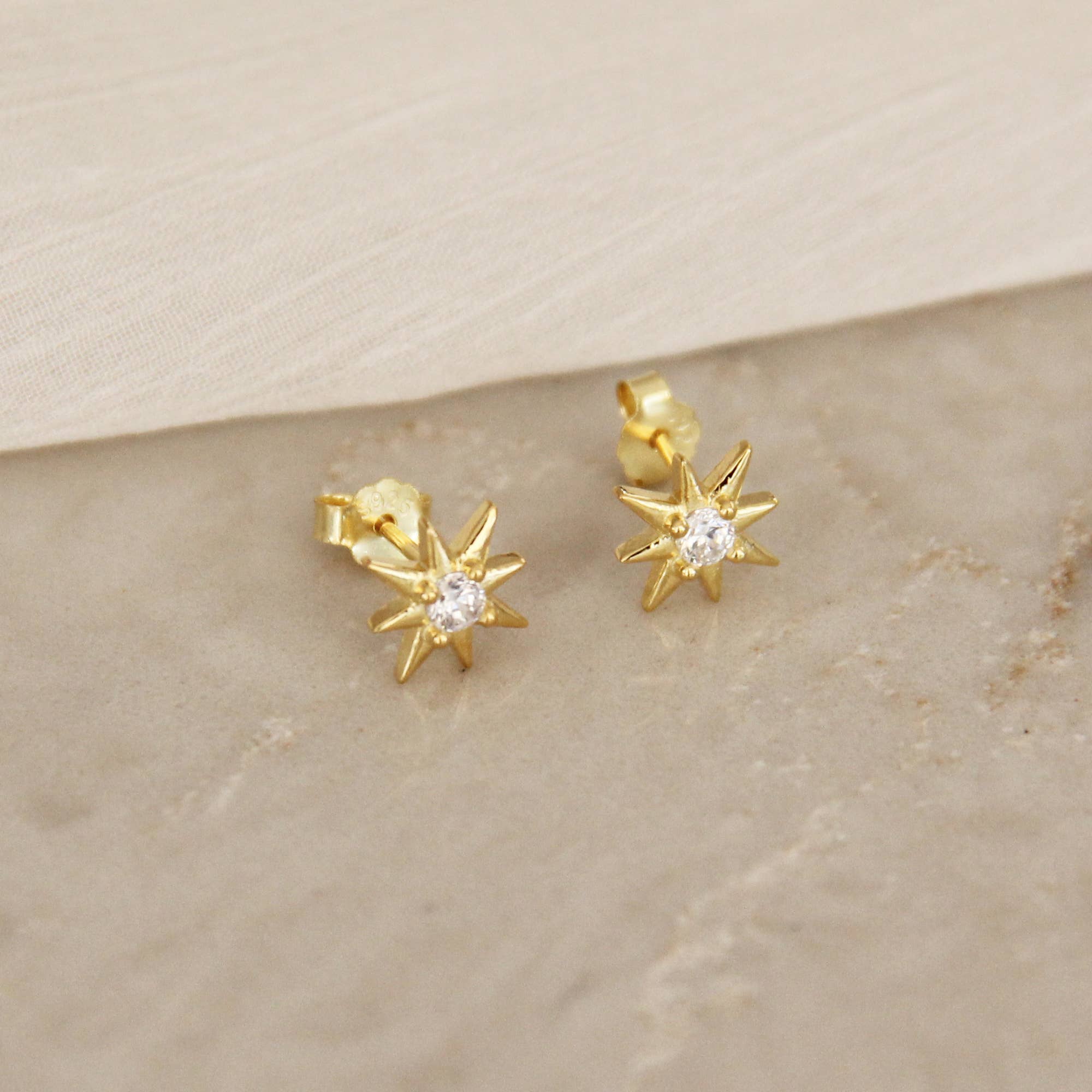 Gold stud star earrings with diamond in the center