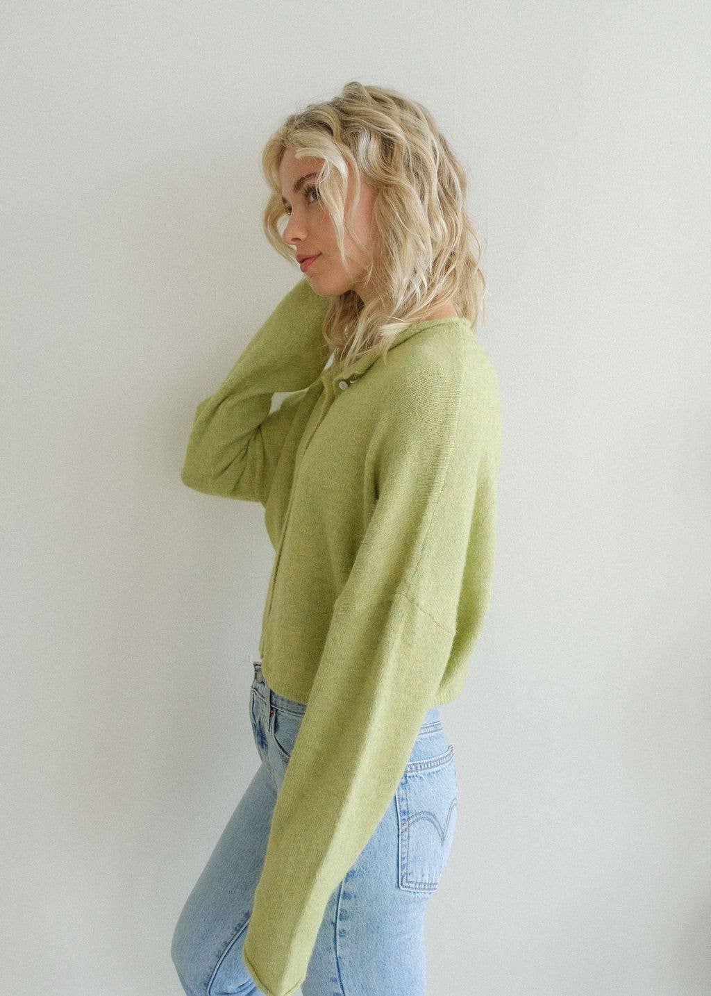 Woman with blonde hair turned to side wearing long sleeve lemongrass cardigan 