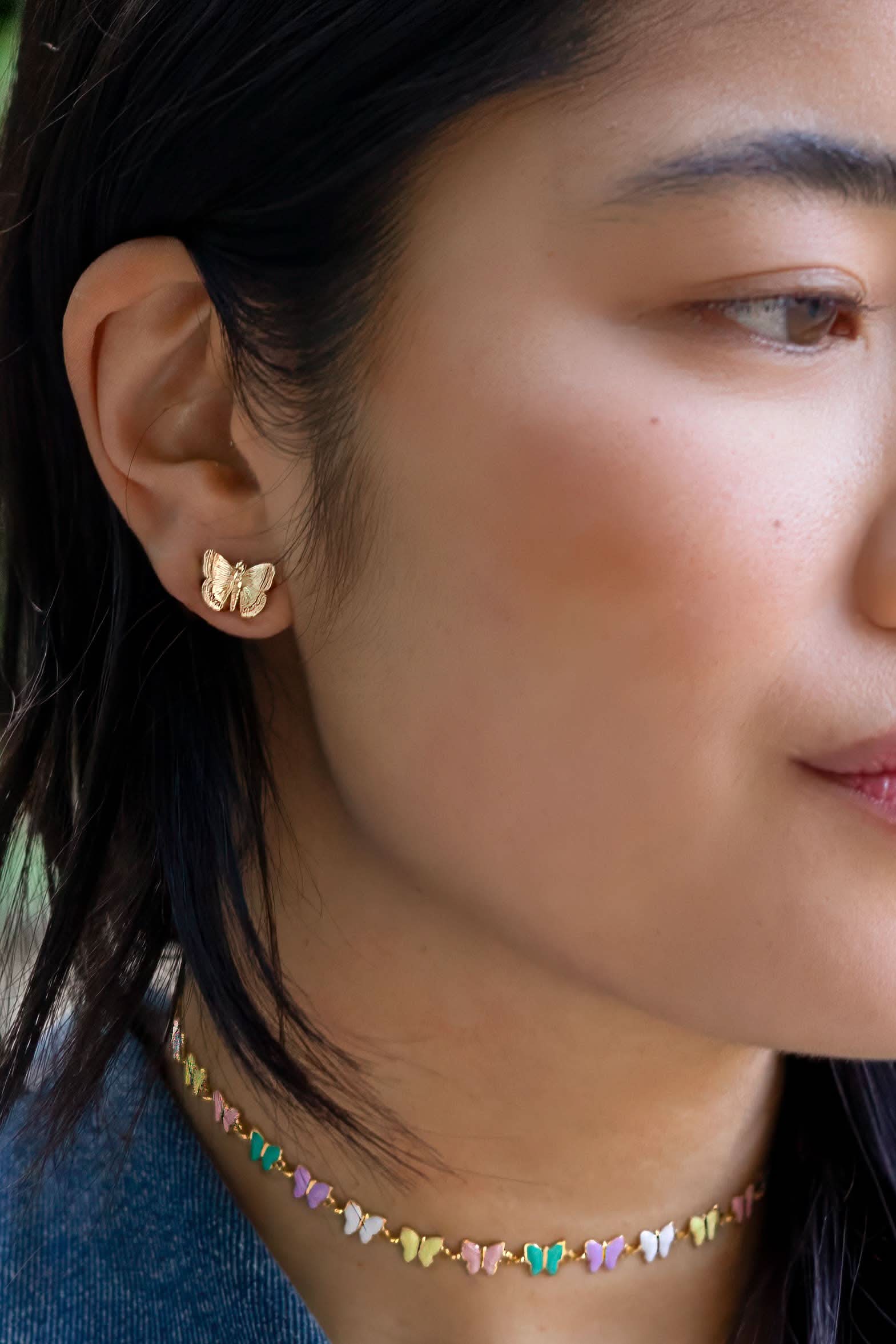 Woman wearing Gold butterfly earring 
