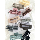 Muted Matte Hair Clips in 10 different colors laying on white fabric next to