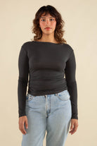 Woman wearing vintage black, shirred waist, long sleeve top 