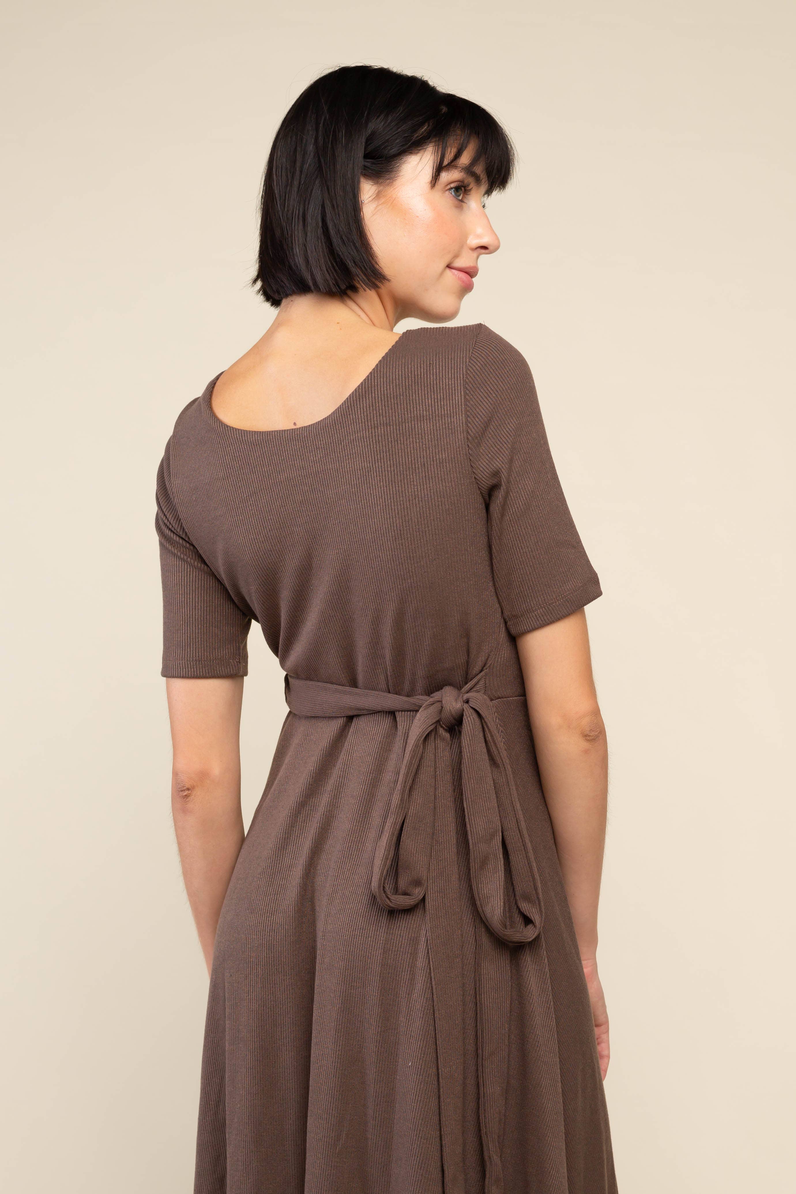 Close up view of Woman wearing brown midi ribbed dress with waist adjustable tie at waist