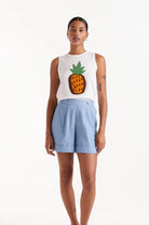 Woman wearing denim like chambray shorts with white sleeveless top 