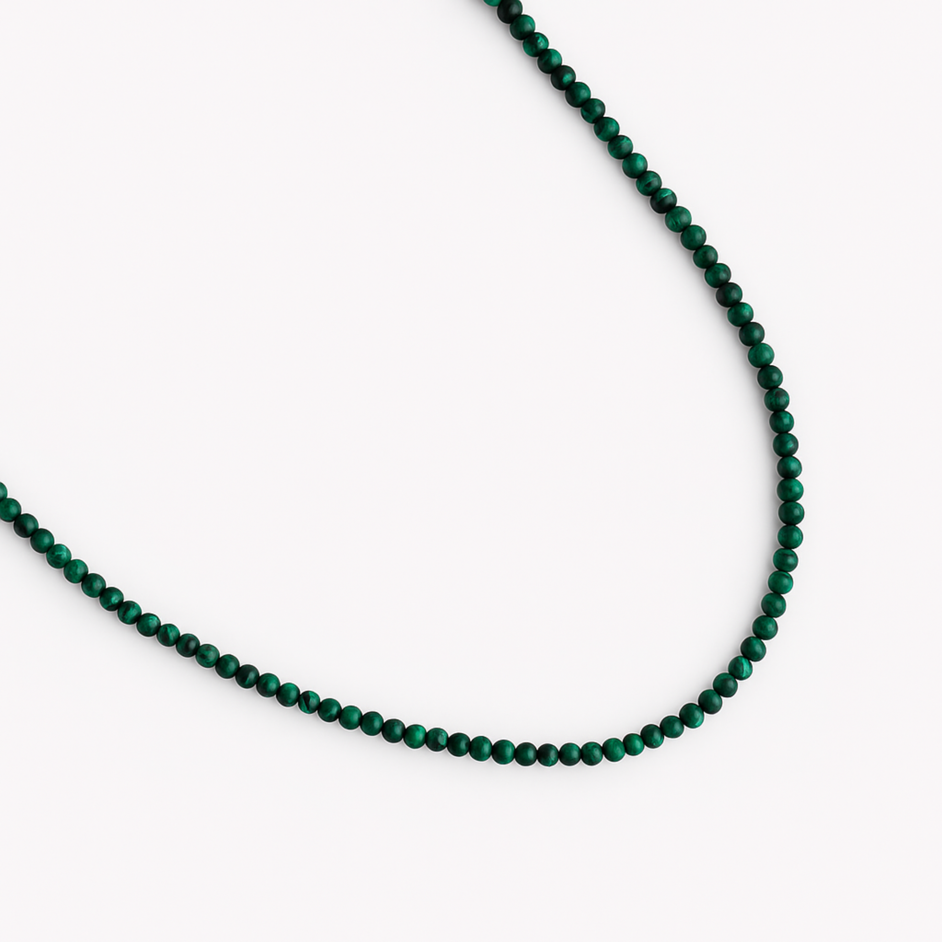 Green beaded necklace on a white background
