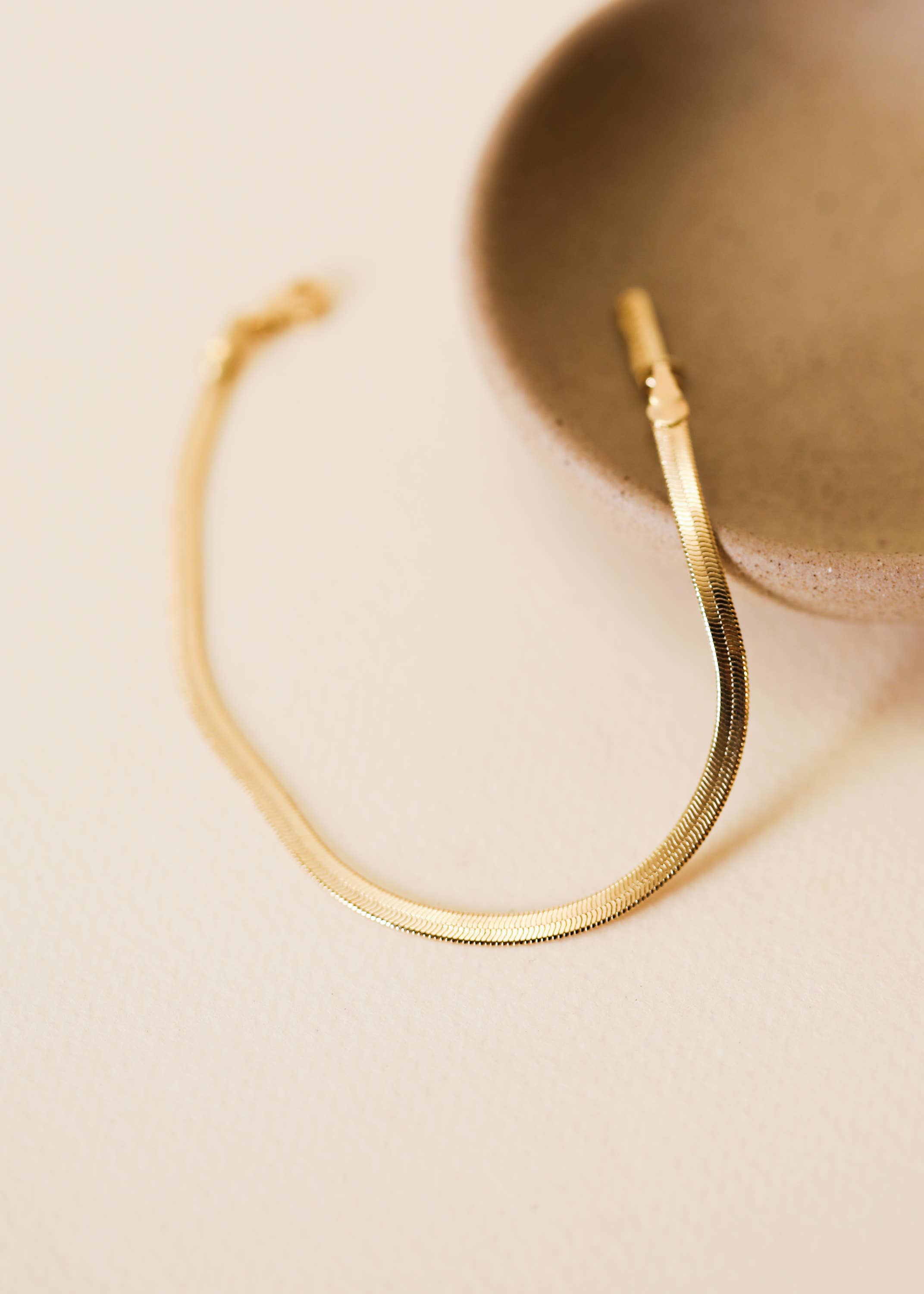 Gold bracelet on a beige background