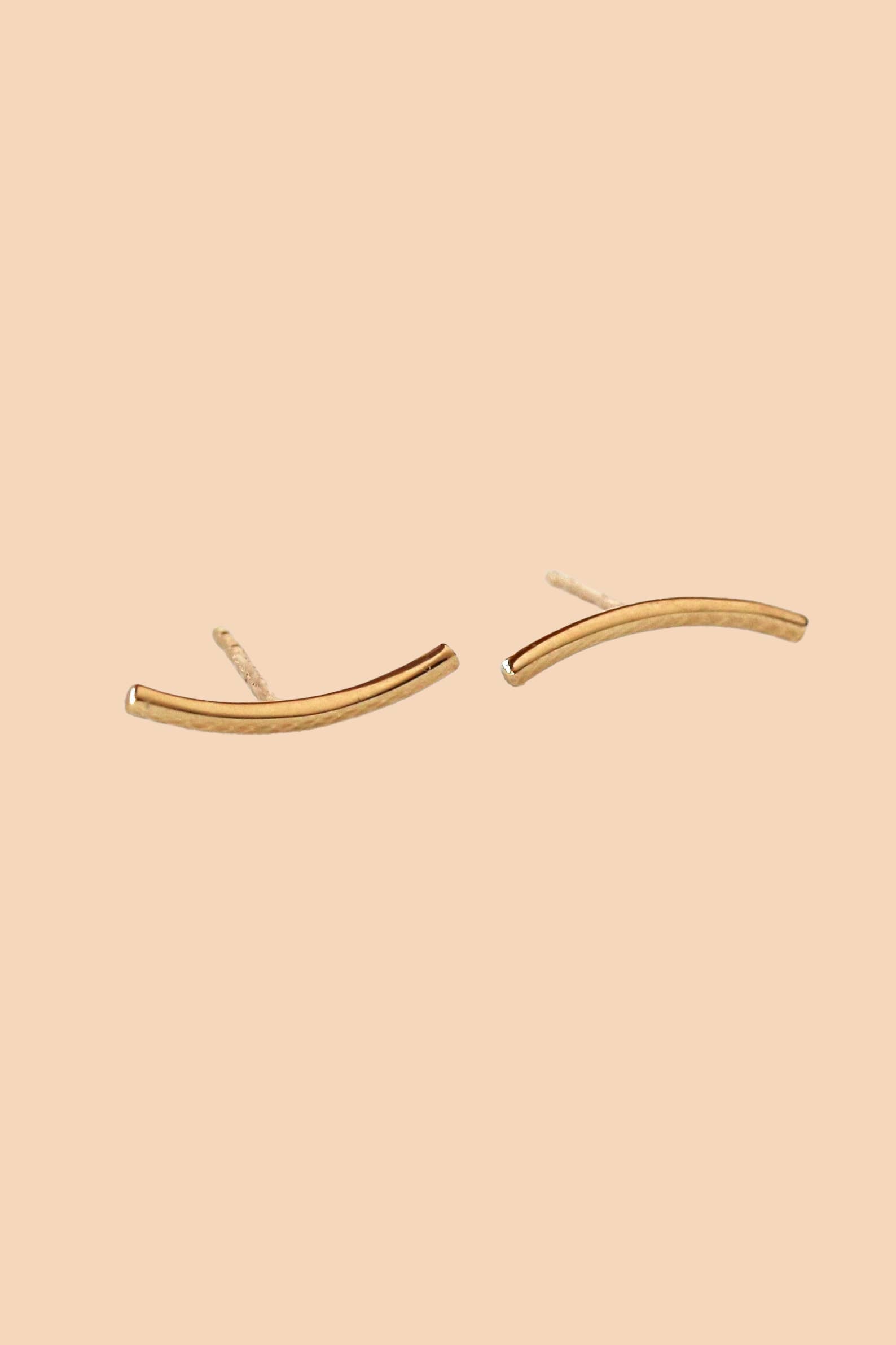 Gold earrings on a beige background