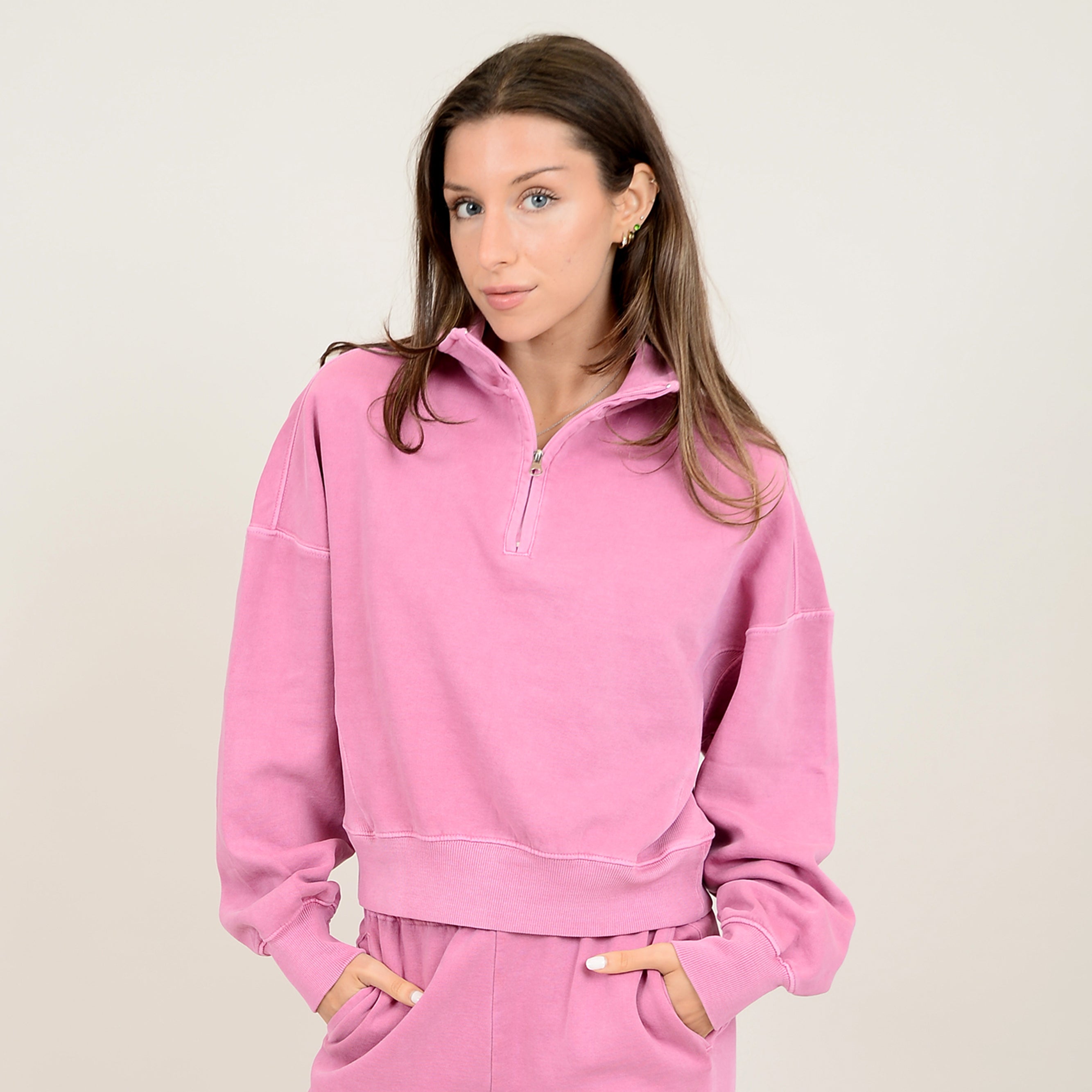 model wearing pink quarter zip sweatshirt