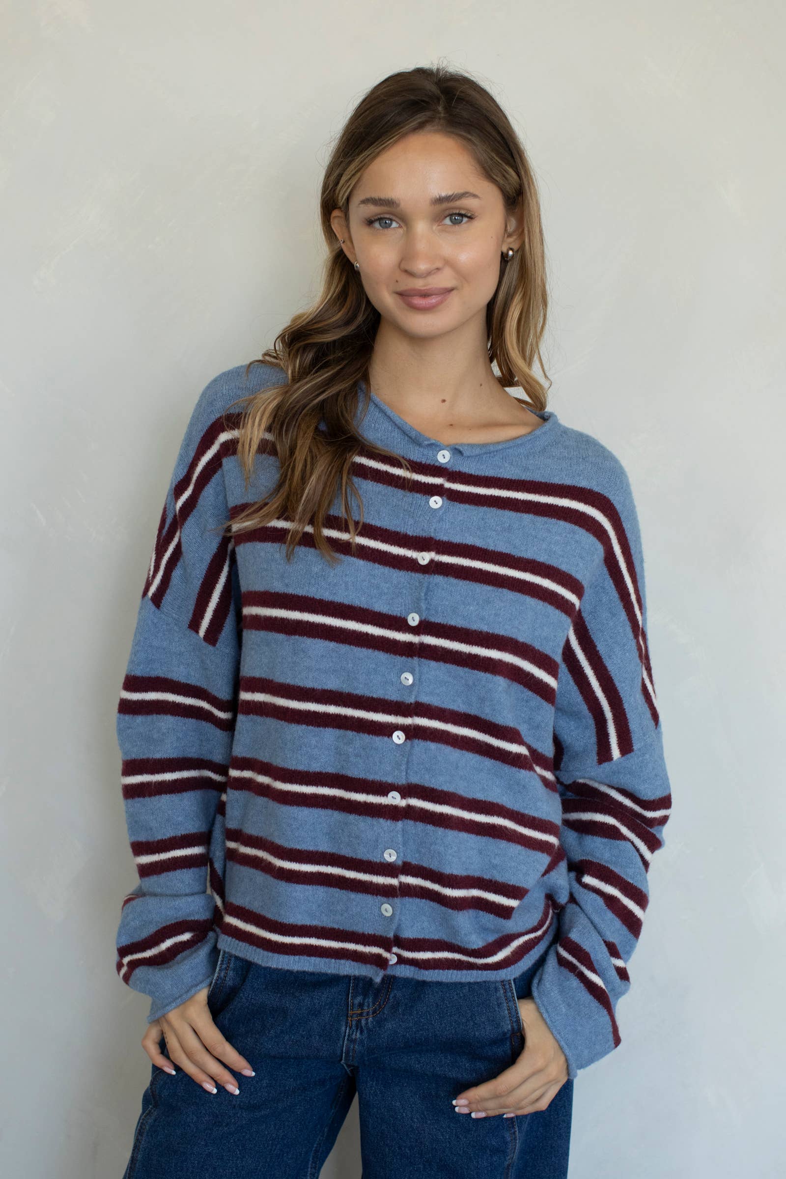 Woman wearing a blue and red striped sweater against a plain background