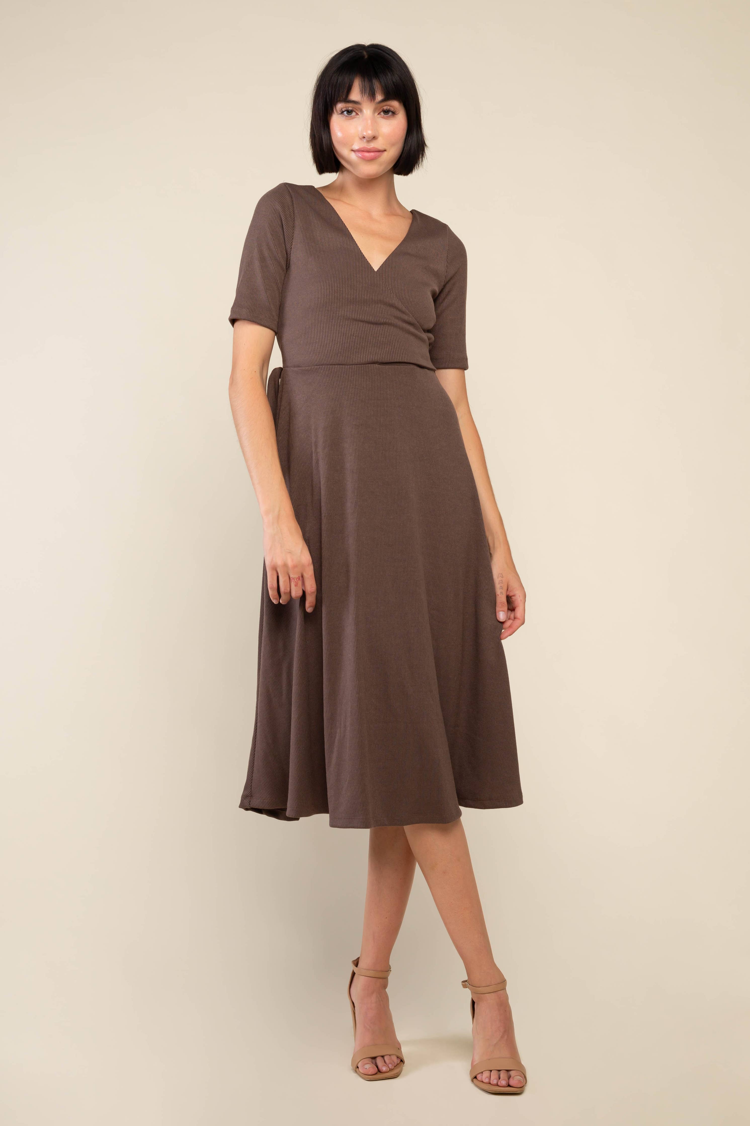 Woman wearing high heels and brown midi ribbed dress with waist adjustable tie at waist