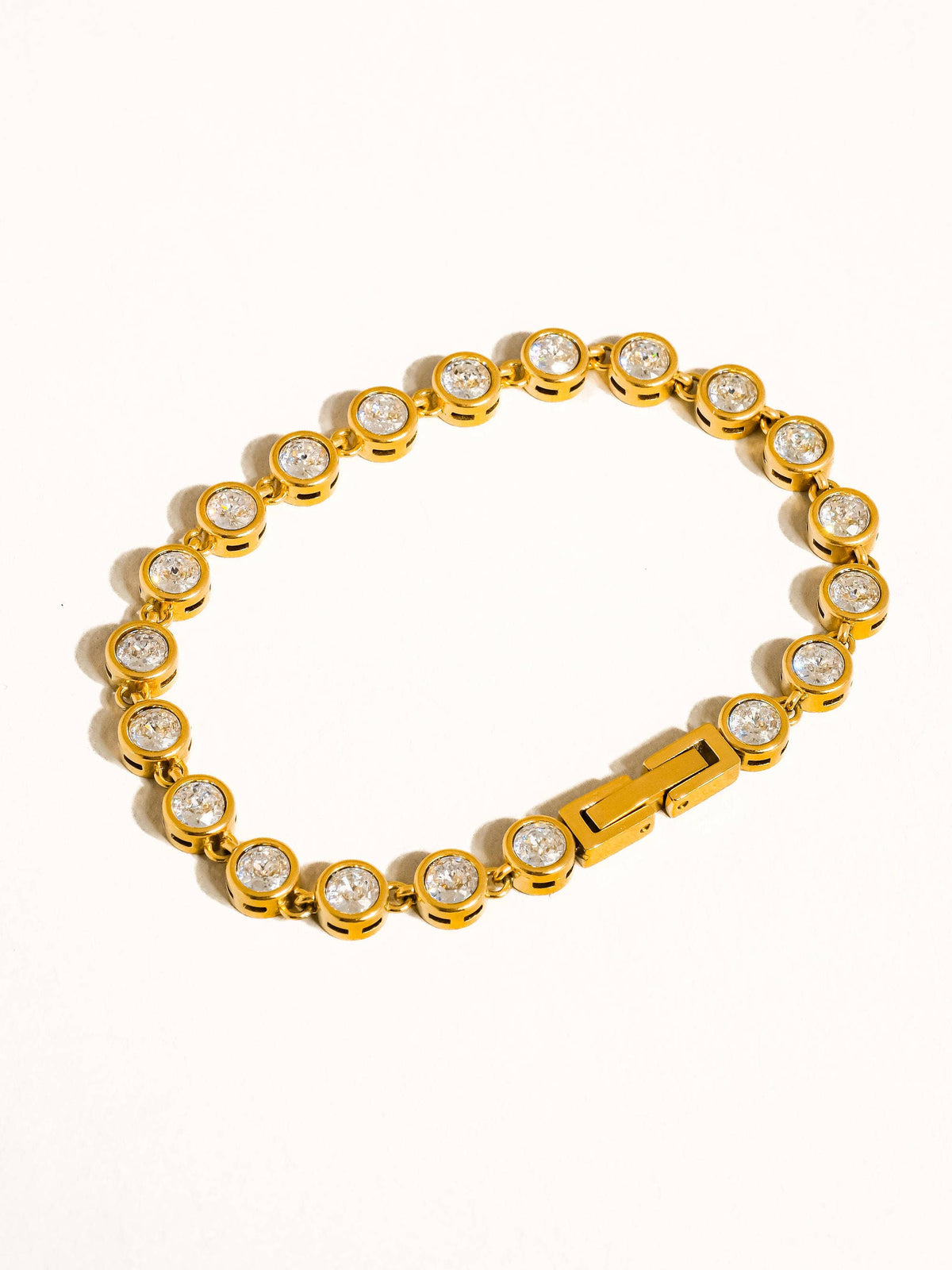 Gold bracelet with embedded crystals on a white background