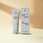 Deordant in a gray squeeze tube standing next to gray packaging box 
