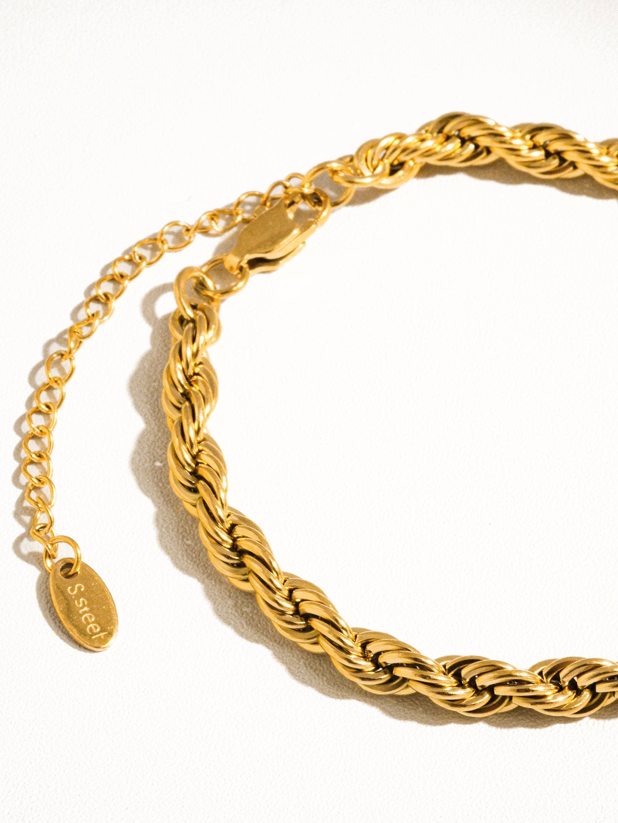 Gold braided bracelet on a white background