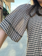 Model wearing Vintage style babydoll dress black and tan gingham pattern with lace details 