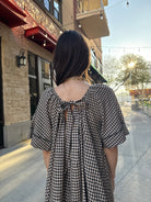 Model wearing Vintage style babydoll dress black and tan gingham pattern with lace details 