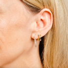 Woman wearing Gold waterproof medium sized hoop tubs with cubic zirconia jewels  