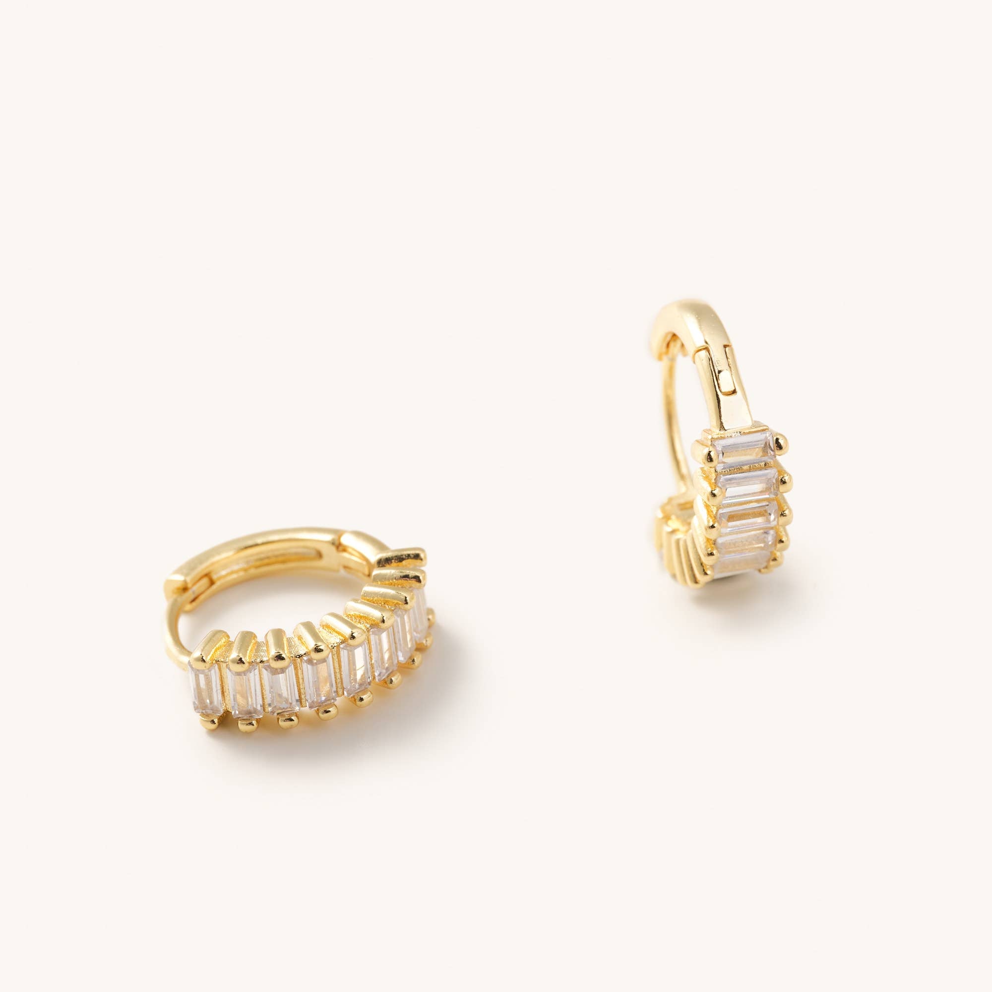 Medium sized waterproof gold CZ hoop earrings laying on a white background 