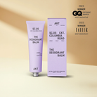deodorant balm in a lavender tube laying on a table next to lavender color packaging 