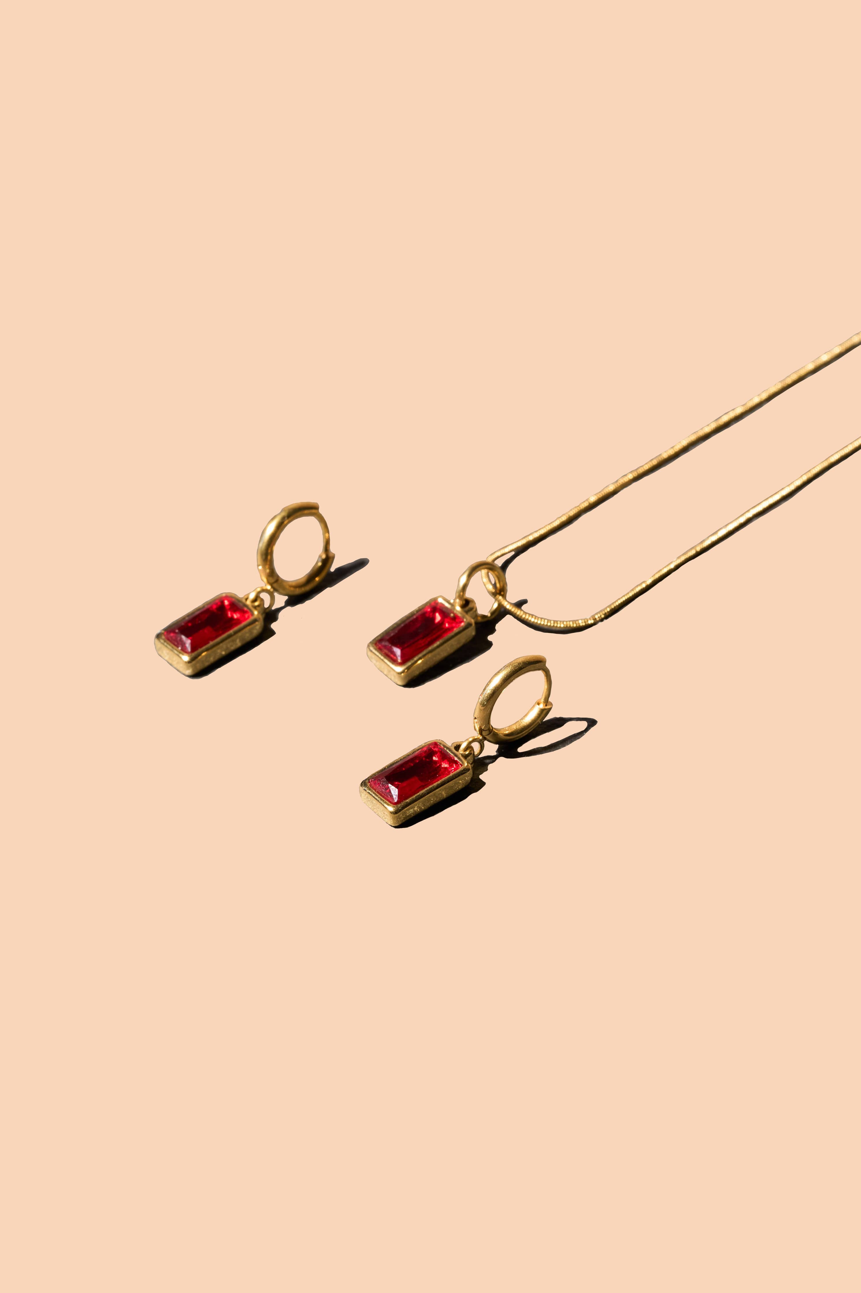 Gold necklace and matching earrings with rectangular red gemstone pendants