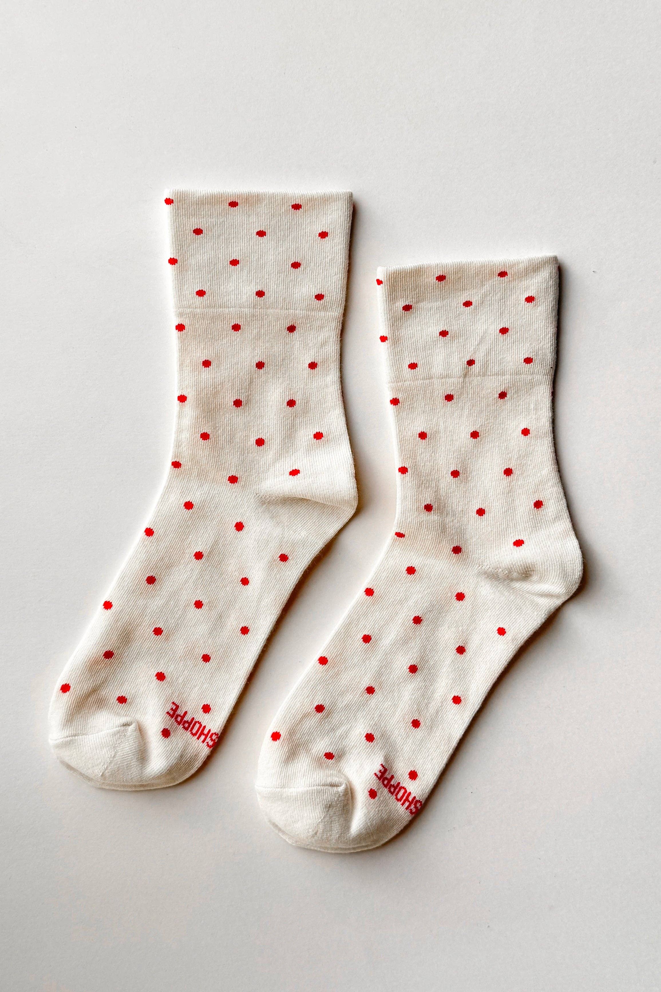 White socks with red polka dots on a light gray background