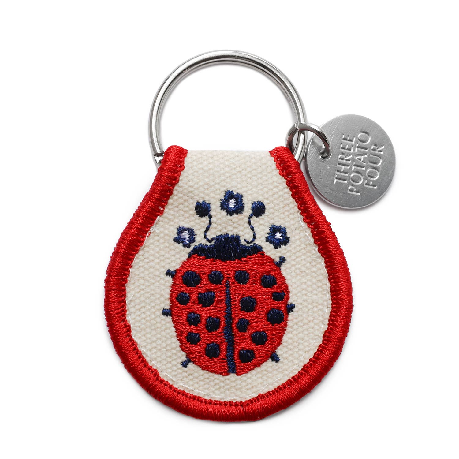 Keychain with a ladybug design and 'Three Potato Four' tag on a white background