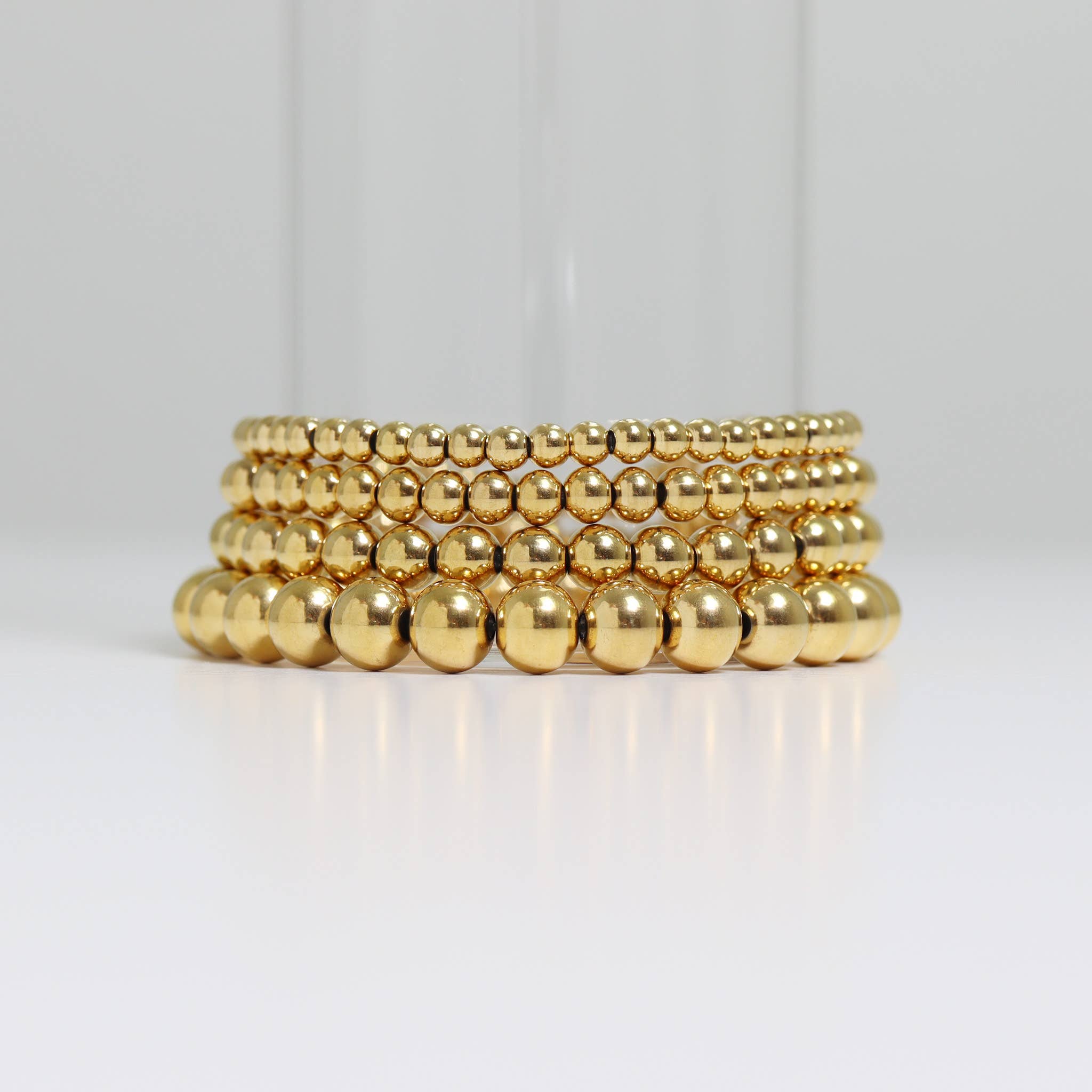 Gold beaded bracelet on a black background