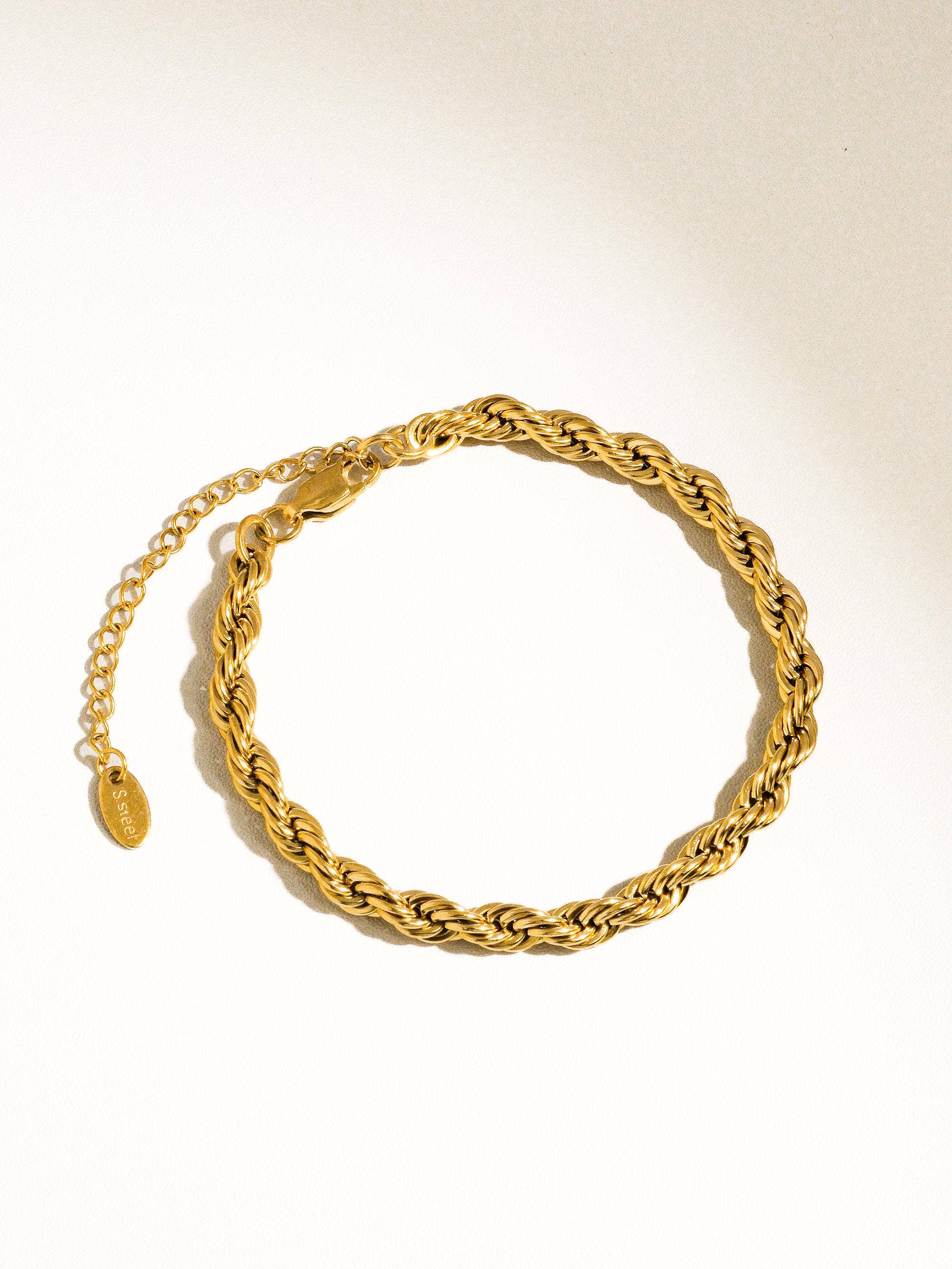 Gold chain bracelet on a light background