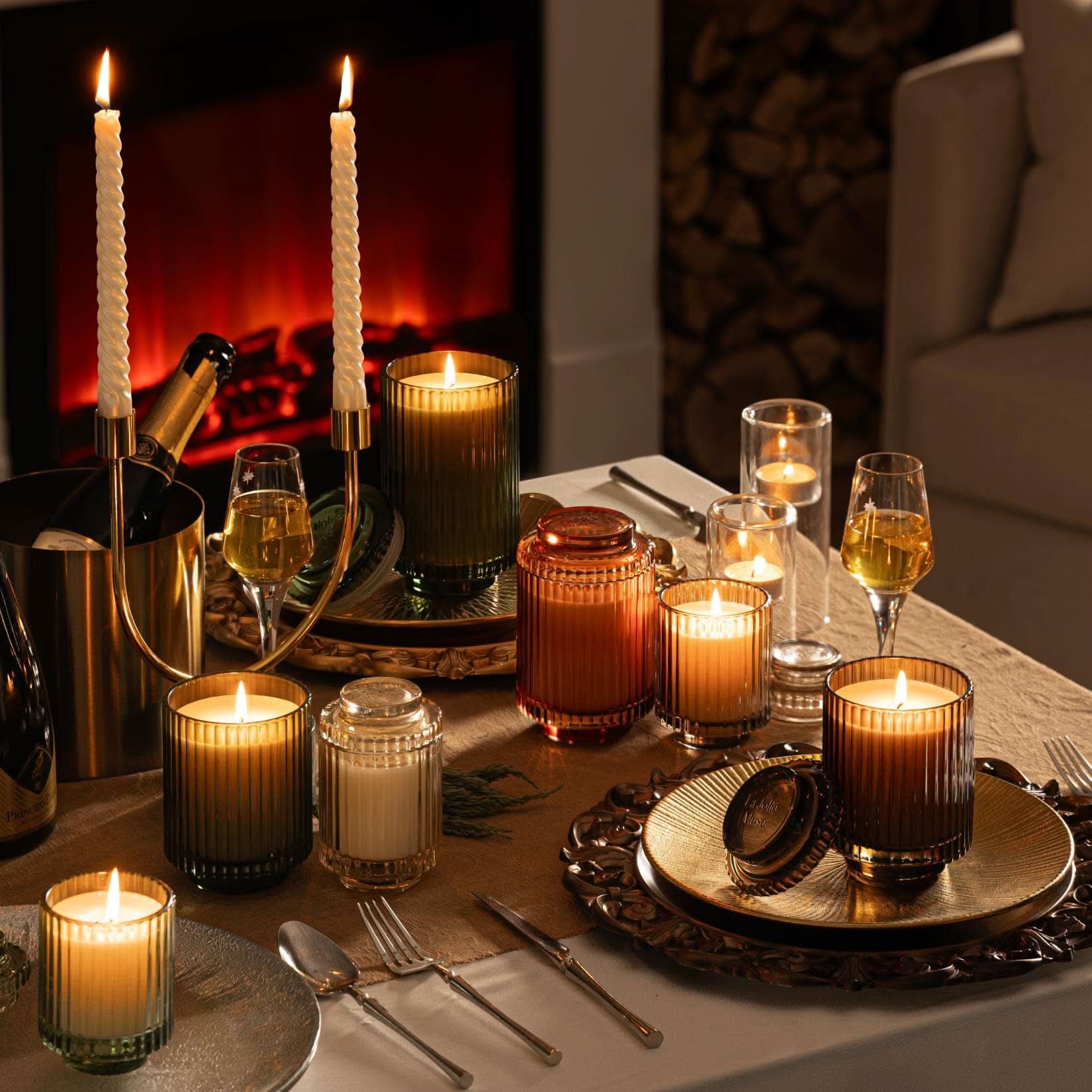 Dining table set with candles and glasses in front of a fireplace