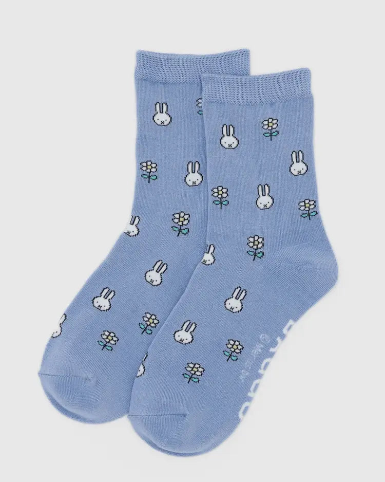 Pair of blue socks with bunny and flower patterns on a light gray background