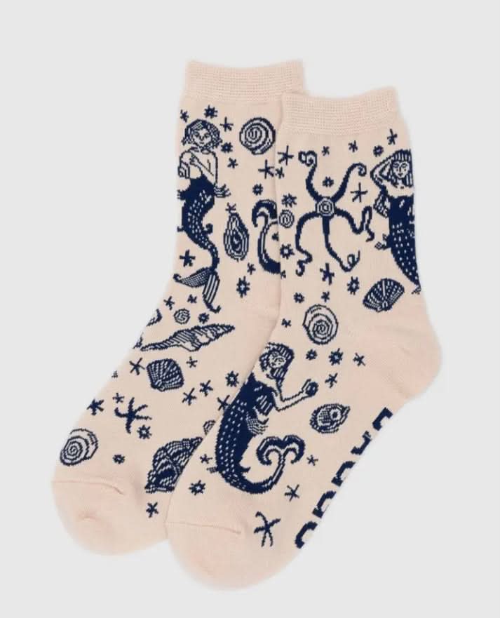 Beige socks with navy mermaid and shell pattern on a white background