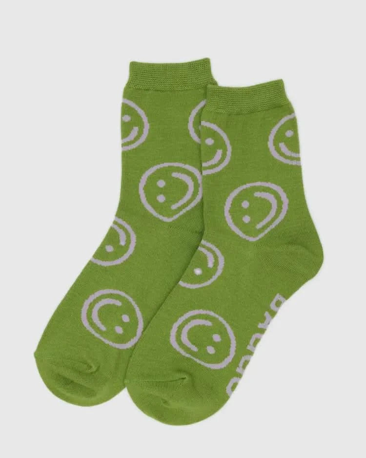 Green socks with smiley face pattern on a white background