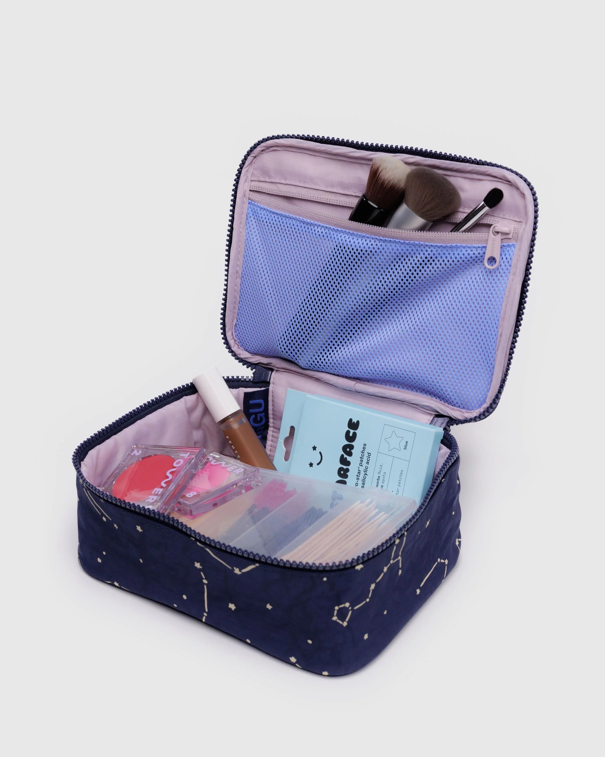 Open makeup bag with cosmetic items on a light gray background