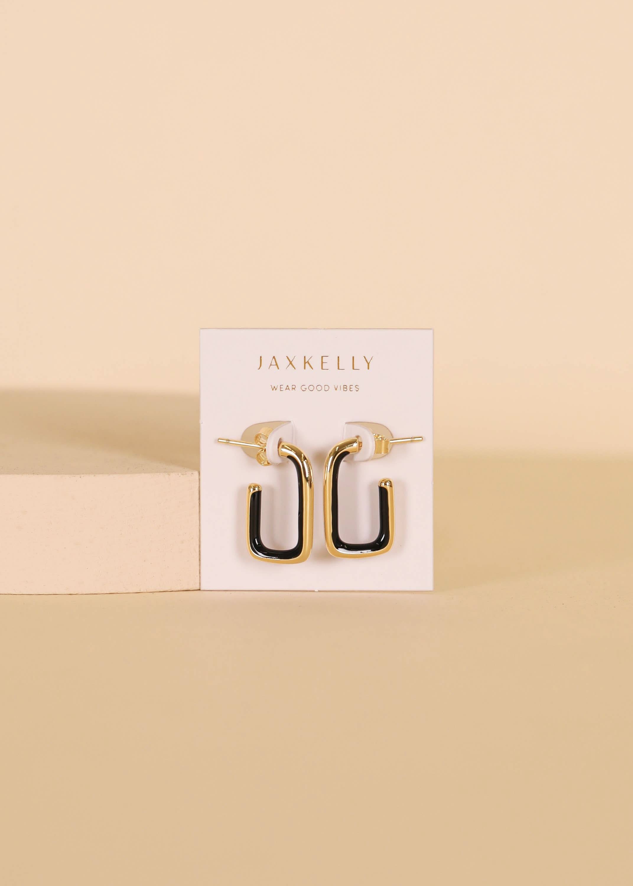 Gold and black earrings on a Jaxkelly branded card against a beige background