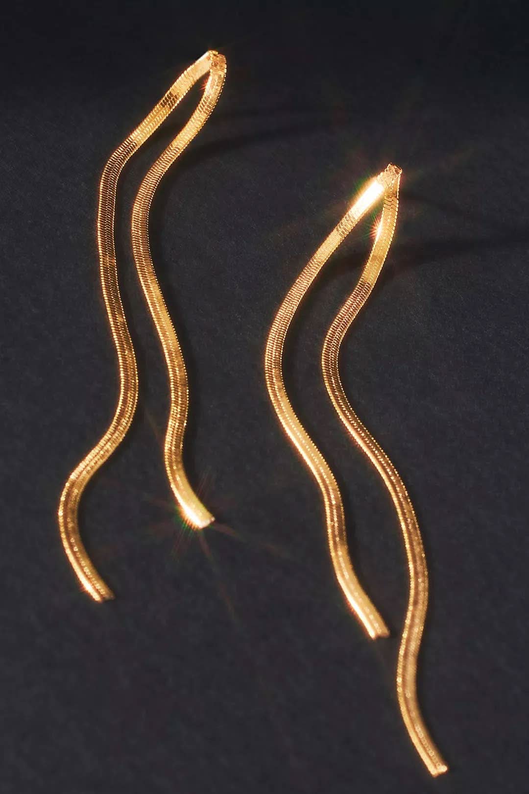 Boogie Nights Earring Two gold hairpins on a dark background