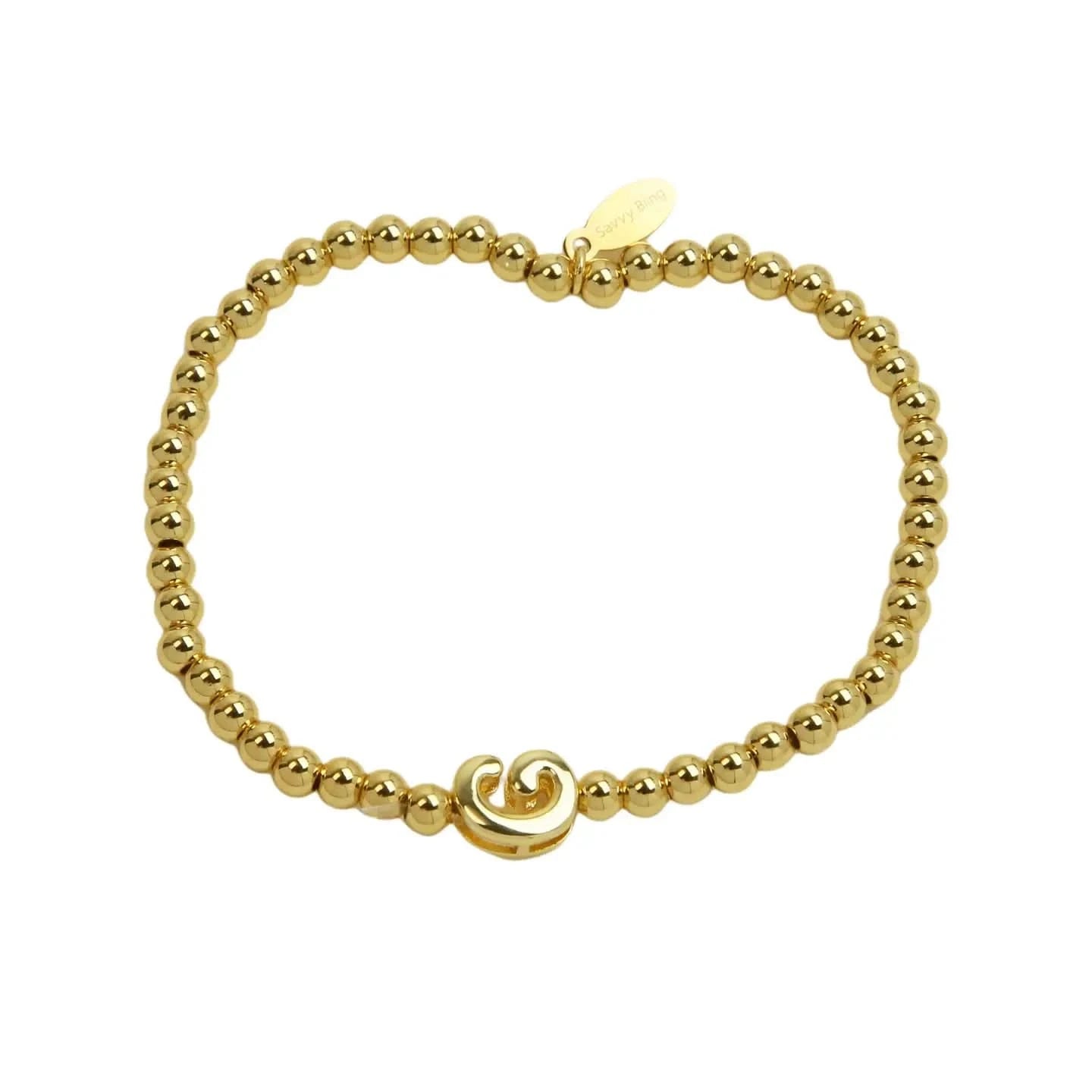Gold beaded bracelet with a wave charm on a white background
