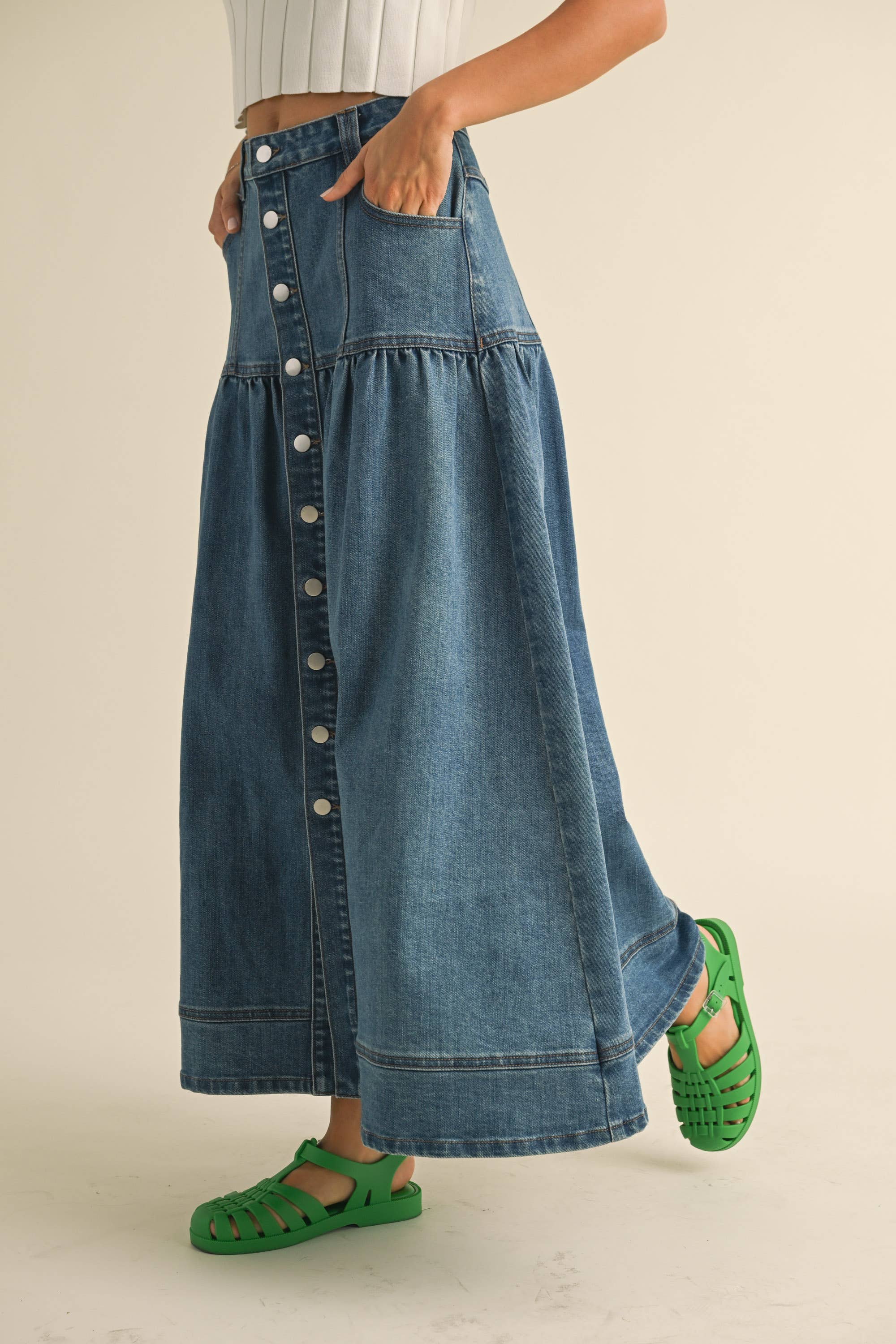 Crafted from classic denim, it features a charming front button closure that adds personality