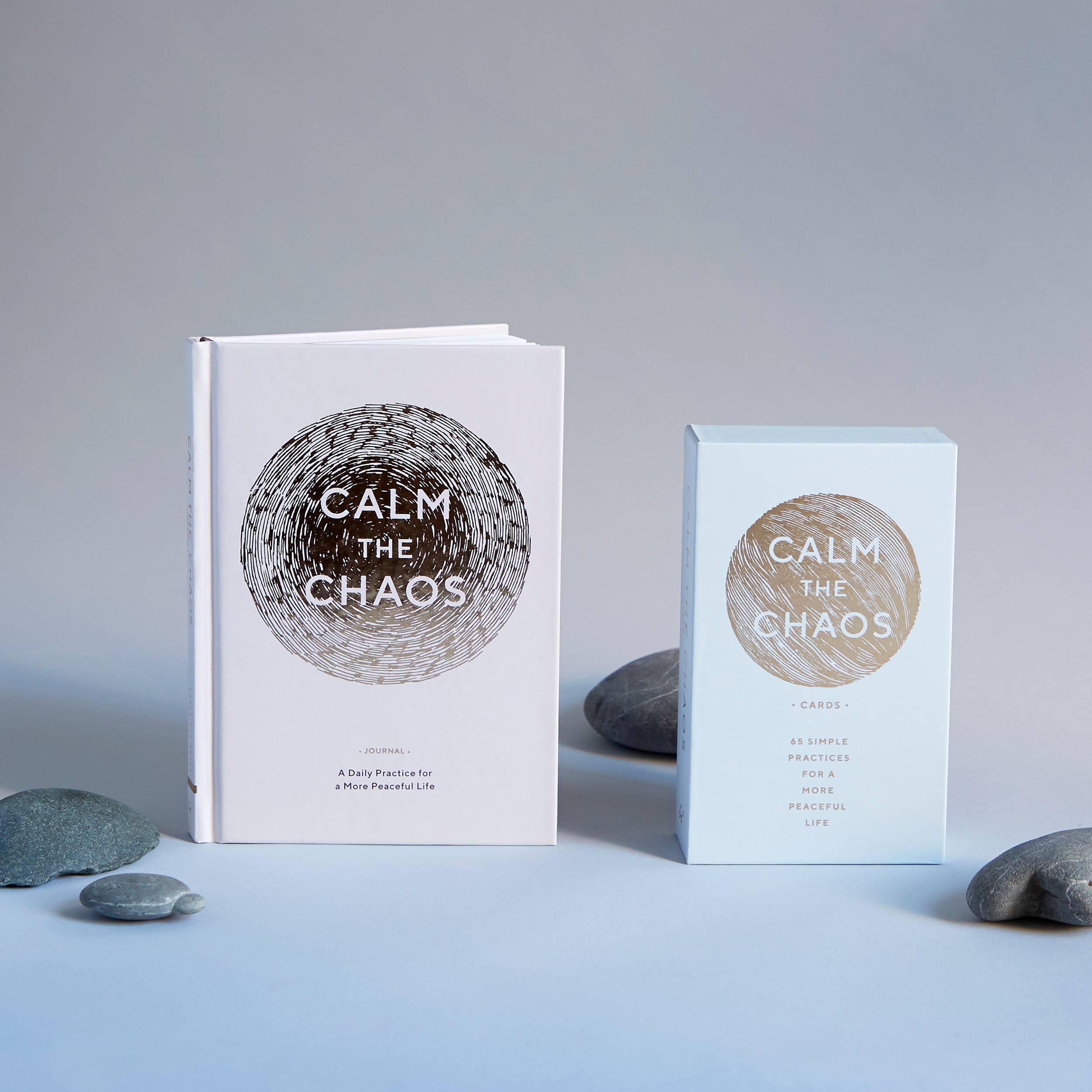 Two books titled 'Calm the Chaos' on a light blue surface with a gray background